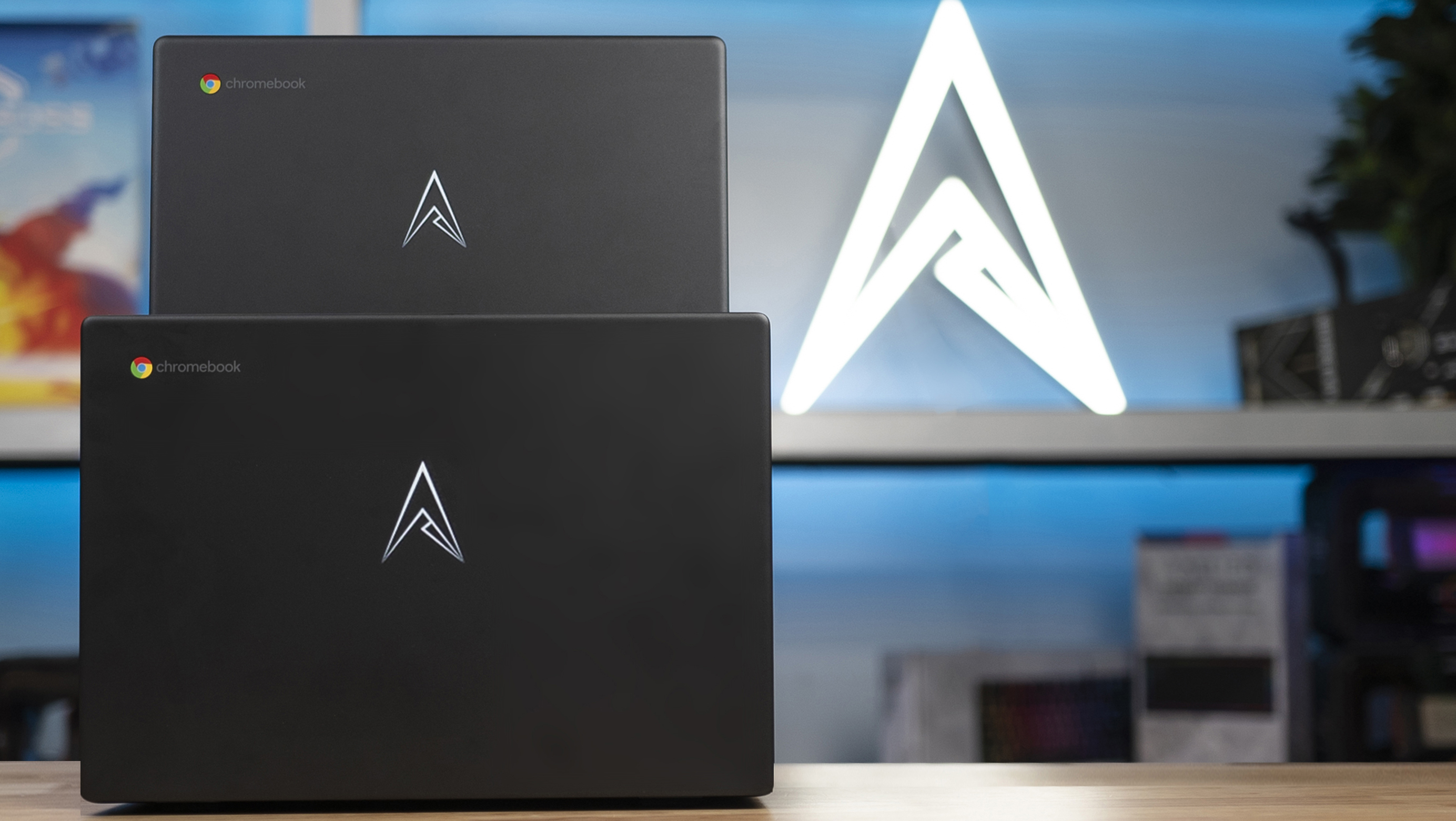 Two Allied Chromebooks standing lid-out in front of the Allied logo